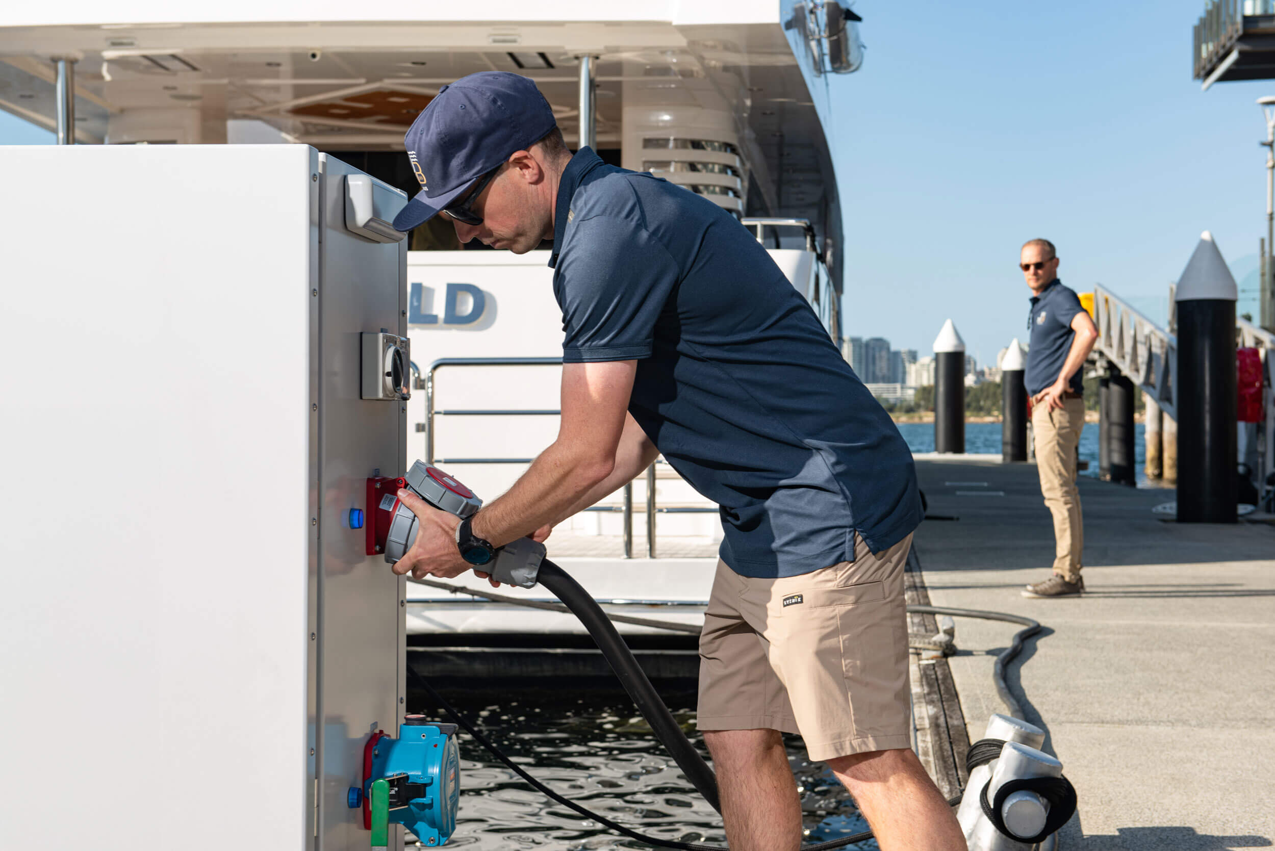 Marina attendant connecting a docked yacht's power source at Jones Bay Superyacht Marina.